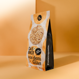 Organic oat bites bread baking mix in a jar, 1,000 g. The product is a granola mix packaged in a glass jar. The jar has a label that says "Das Brot aus dem Glas" (The Bread from the Glass) and "Haferhäppchen" (Oat Bites).