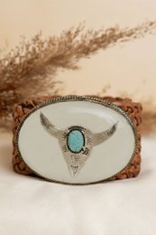 Small brown leather belt with a metal buckle, packaged in a polka dot gift box.