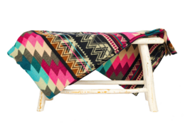 Colorful Ecuadorian alpaca blanket with native geometric patterns in pink, teal, and black.