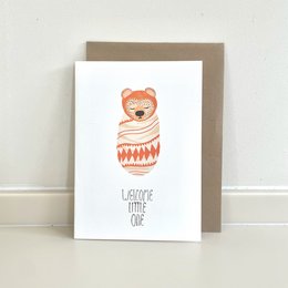 Adorable baby bear in a cozy sweater on a greeting card. Ideal for baby showers, new parents, or any occasion to celebrate a little one.