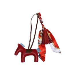  Decorative red and white horse charm with tassels and beads, suitable for hanging or attaching to bags or accessories.