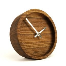 Large cylindrical table clock made of oak or black walnut wood with a minimalist design and analog clock face.