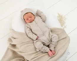  Cozy sand-colored ribbed jersey baby suit with a soft, plush texture and a comfortable hooded design.
