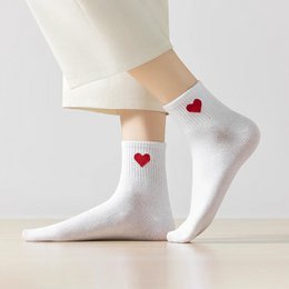 White socks with red heart patterns, suitable for casual or formal wear.