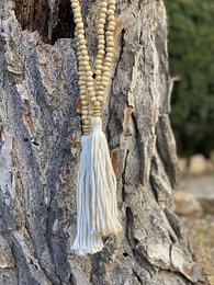  Wooden pendant with beaded tassel, featuring a natural, earthy design with a textured wooden base and off-white tassel.