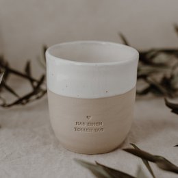 A white ceramic mug with a speckled pattern, featuring the text "Great Day" printed on the side. The mug is surrounded by olive branches, creating a natural and earthy aesthetic.