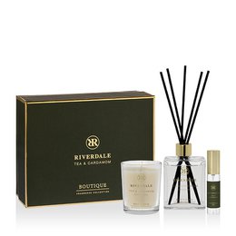  A gift box containing a tea and cardamom scented candle, reed diffuser, and essential oil. The box is made of dark green and gold packaging, giving it a premium and luxurious appearance.