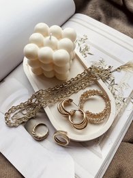 Oval decorative tray in various colors including snow white, confetti, beige sand, seashells, dusty pink marble, beige marble, midnight black marble, pastel love, terracotta sand, seashells pink, and snow white sand. The tray features a unique textured surface and wooden legs.