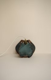 Dark green table lamp with woven shade, suitable for ceiling or floor placement.