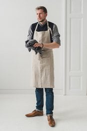 Unisex linen apron in various neutral colors including natural, white, gray, and black. Features a simple, minimalist design suitable for both men and women.