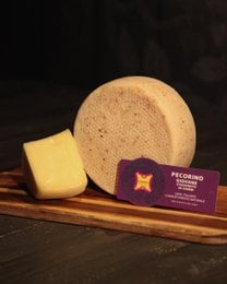 "Pecorino giovane aged 30 days artisanal sheep cheese, pale yellow wheel, purple label, Italian"