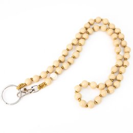 Beige wooden beaded keychain with metal clasp.