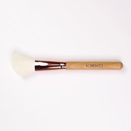 Soft, fluffy blush brush with wooden handle for seamless application of powder blush.
