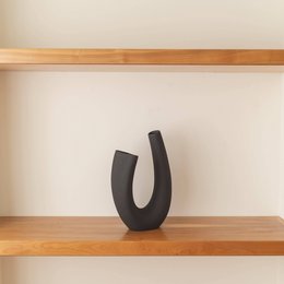 Tall, cylindrical vase in white, cream, and black colors with a modern, minimalist design.