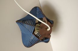 Dark blue table lamp with adjustable cord for ceiling or tabletop placement. Features a unique geometric design in shades of blue.