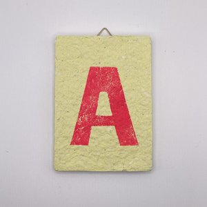 Letter -  roze letter op gele tegel