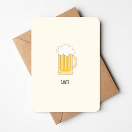 A greeting card featuring a simple illustration of a beer glass with the text "Sante" below it. The card is made of cream-colored paper and is paired with a brown envelope, giving it a rustic, handmade feel.