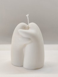 A tall, round, white pillar candle with a twisted, organic shape.