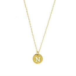 Gold-toned necklace with a round pendant featuring the letter 'N'. The necklace has a delicate chain and a simple, elegant design suitable for everyday wear.