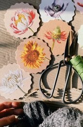 Decorative coasters featuring a variety of floral motifs including sunflowers, roses, and other vibrant blooms. Ideal for adding a touch of nature-inspired style to any table or living space.