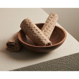 Sand beige cotton waffle weave face towel, soft textured rolled towel, neutral earth tone hand towel.