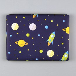 Wrapping paper with a space theme featuring yellow rockets, planets, and stars on a dark blue background.