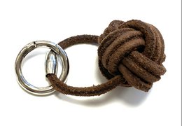 Keychain with a ship-shaped button made of brown leather material.