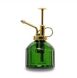  A green glass plant mister with a brass sprayer, designed for watering houseplants.
