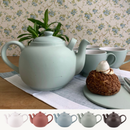 A 2.5-liter teapot in a variety of colors including white, terracotta rose, ice, leaf, and almost black. The teapot features a simple, minimalist design with a green plant accent.