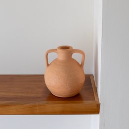  Handmade ceramic pottery vase with a round, bulbous shape and two handles. The vase is made of terracotta clay and has a natural, earthy color.