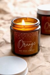 Spiced orange natural soy wax candle with essential oils, available in regular and festive variants. Features a warm, citrusy scent.
