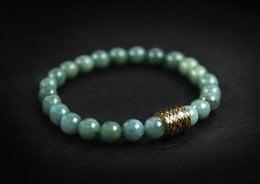 Elegant green beaded bracelet with gold-tone accent bead.