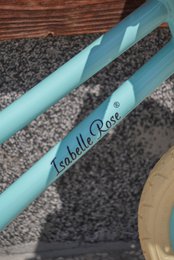 Balancecykel i pastelblå farve med flettet kurv Isabelle Rose