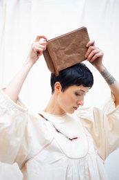 Camel-colored leather clutch with a minimalist design.