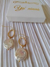 Elegant gold-toned baroque pearl earrings with intricate textured details.