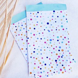  Colorful polka dot gift bag with assorted dots in various sizes and shades of blue, pink, and gold.