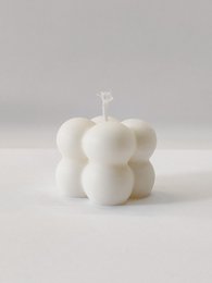 Small white bubble candle with a round, spherical shape.