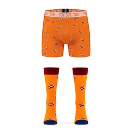 'Orange boxershorts and socks with a repeating pattern of small black and white icons, likely representing the product name "Willem". The boxershorts have a waistband with the text "SIR TOM" printed on it.'
