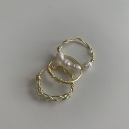White jade stone ring with gold and silver twisted band designs.