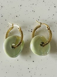  Elegant green ceramic hoop earrings with a swirling design, made of high-quality materials for a stylish and sophisticated look.
