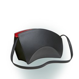 A sleek, modern handbag in a black color with contrasting red trim. The bag has a curved, crescent-shaped design and a detachable shoulder strap for versatile carrying options.