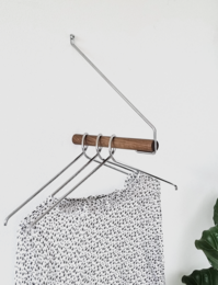 Smoked oak and chrome coat rack with a simple, minimalist design. Features a wooden bar for hanging clothes and a metal frame for stability.