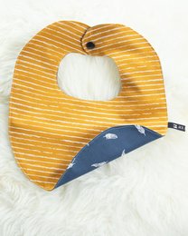 A striped yellow bib with a snap button closure, suitable for infants 6-12 months old. The bib features a simple, minimalist design.