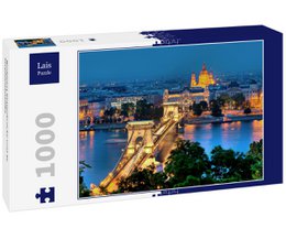  A 1000-piece puzzle depicting the Chain Bridge and St. Stephen's Basilica in Budapest, Hungary at night. The image shows the iconic landmarks illuminated against a blue sky.