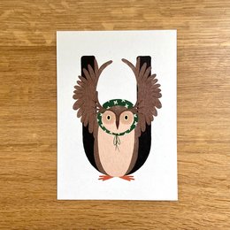 Whimsical greeting card featuring a cute owl with large wings and a friendly expression. The card is suitable for a variety of occasions.
