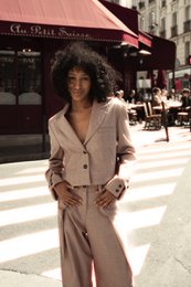  Cropped unstructured wool blazer in a soft pink color, made in Italy. Features a relaxed, oversized fit and a notched lapel collar.