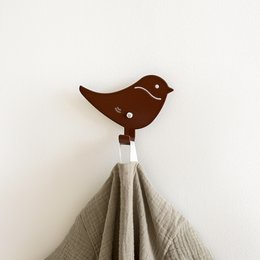 Brown bird-shaped wall hook for hanging kids' clothing and accessories.