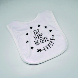 White bib with black text "Eat, sleep, be cute" and arrow design.
