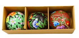  A set of 3 assorted Christmas ornament balls in a wooden box. The ornaments feature colorful floral and nature-inspired designs.