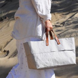 Large white canvas weekend bag with brown leather handles and accents.